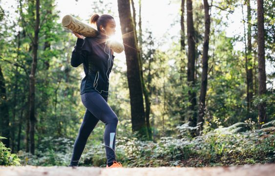 Woman working out in forrest lifting weights